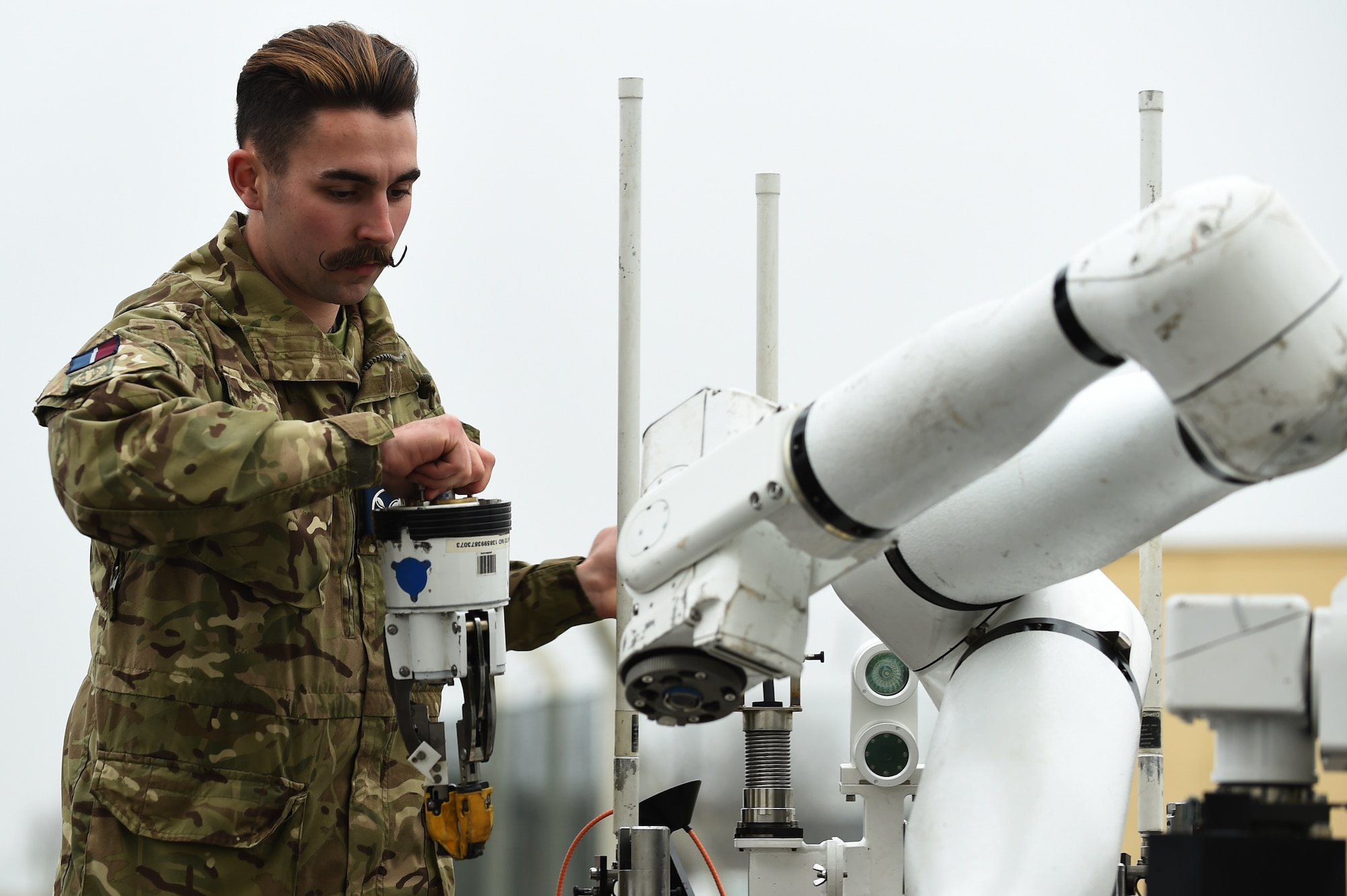 Royal Air Force Senior Aircraftsman Technician Zac Herdman, with the 5131 Bomb Disposal Squadron at RAF Wittering, attaches an arm to a bomb disposal robot during a training exercise at RAF Alconbury, England, March 17, 2015. The exercise allowed UK and U.S. Armed Forces to partner and share best practices while responding to a simulated incident. (U.S. Air Force photo by Staff Sgt. Jarad A. Denton/Released)
