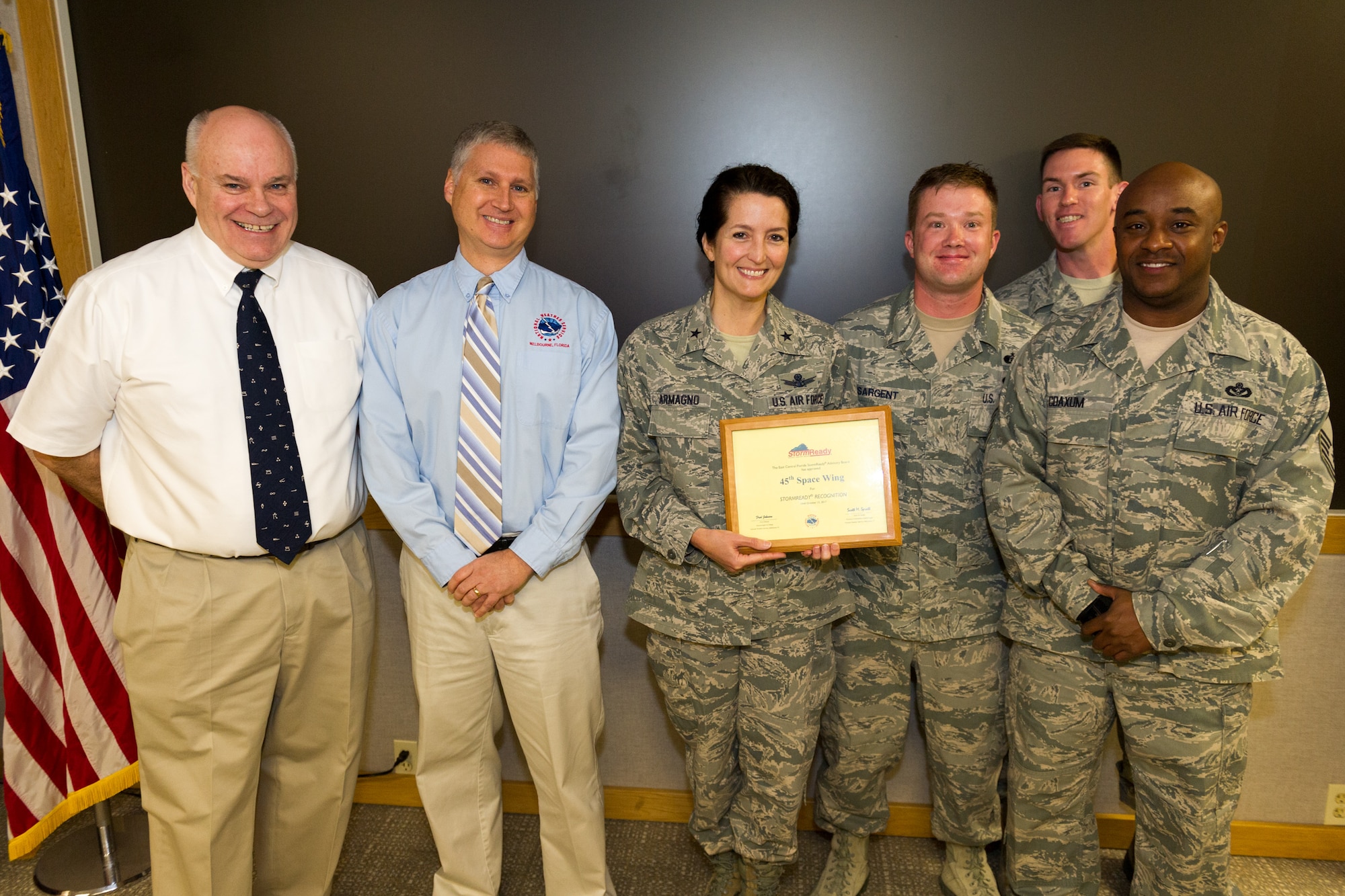 Brig. Gen. Nina Armagno, 45th Space Wing commander, and members of the 45th Civil Engineer Squadron, accept a StormReady certification certificate from members of the National Weather Service, March 11, 2015, at Patrick Air Force Base, Fla. National Weather Service officials recognized Patrick AFB as a StormReady site. The StormReady program helps community leaders and residents better prepare for hazardous weather and flooding. StormReady sites have made a strong commitment to implement the infrastructure and systems needed to save lives and protect property when severe weather strikes. (U.S. Air Force photo/Cory Long) (Released)