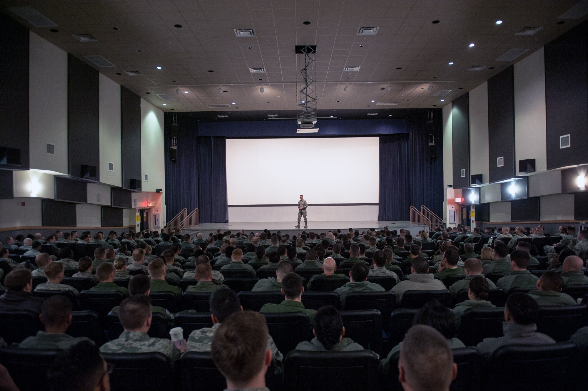 Col. Ken “Wolf” Ekman, 8th Fighter Wing commander, briefs during an all-call in the base theater at Kunsan Air Base, Republic of Korea, March 16, 2015. Ekman spoke to Airmen about resiliency and how they contribute to it through the wingman culture. (U.S. Air Force photo by Senior Airman Taylor Curry/Released)