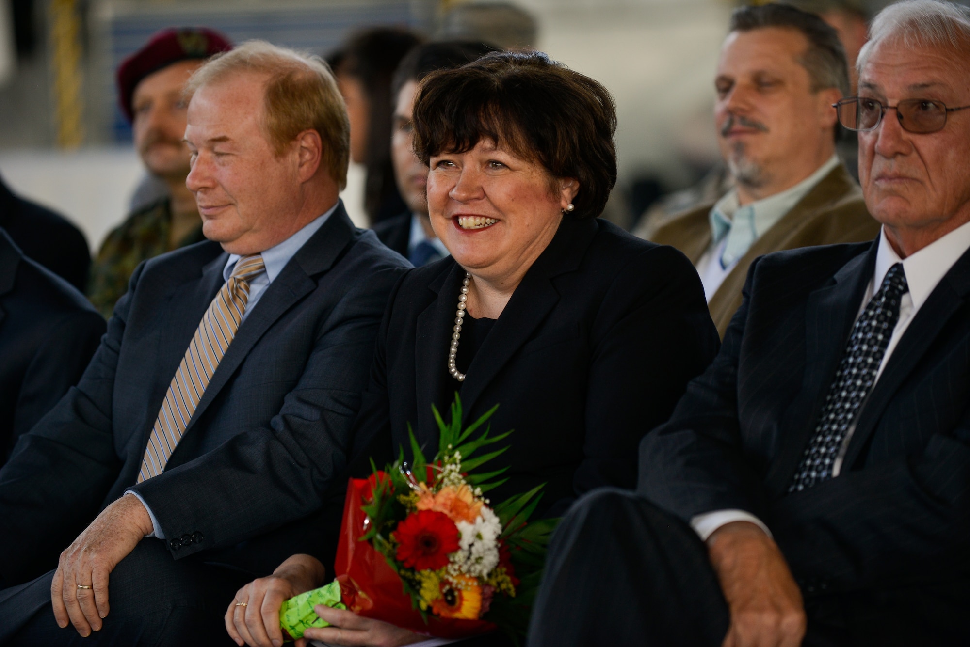 Helen Pryor, sister of Col. Andra Kniep, 435th Air Ground Operations Wing and 435th Air Expeditionary Wing commander, smiles after receiving flowers during an assumption of command ceremony March 16, 2015, at Ramstein Air Base, Germany. During the ceremony, Kniep thanked her family for their continued support throughout her career. (U.S. Air Force photo/Senior Airman Nicole Sikorski)
