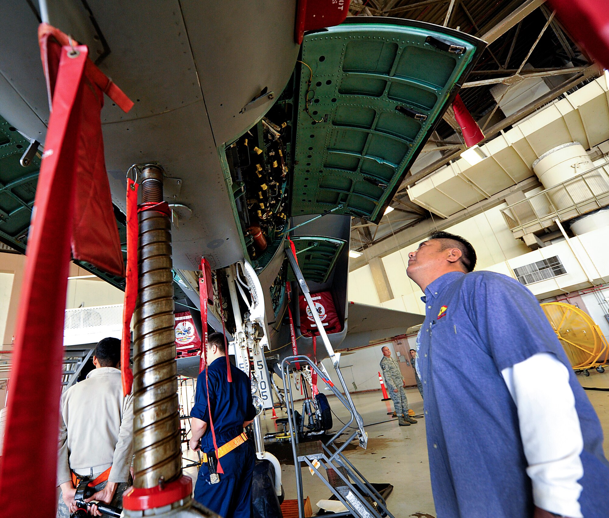 Genshiro Take, Kyushu Area Japan Chamber of Commerce and Industry Youth Division president, looks inside the panel of a 67th Fighter Squadron F-15C Eagle fighter jet during a tour on Kadena Air Base, Japan, March 17, 2015. Eight honorary commanders were able to tour the 18th Maintenance Group facilities and see the F-15 and the HH-60G Pave Hawk helicopter. (U.S. Air Force photo by Naoto Anazawa)