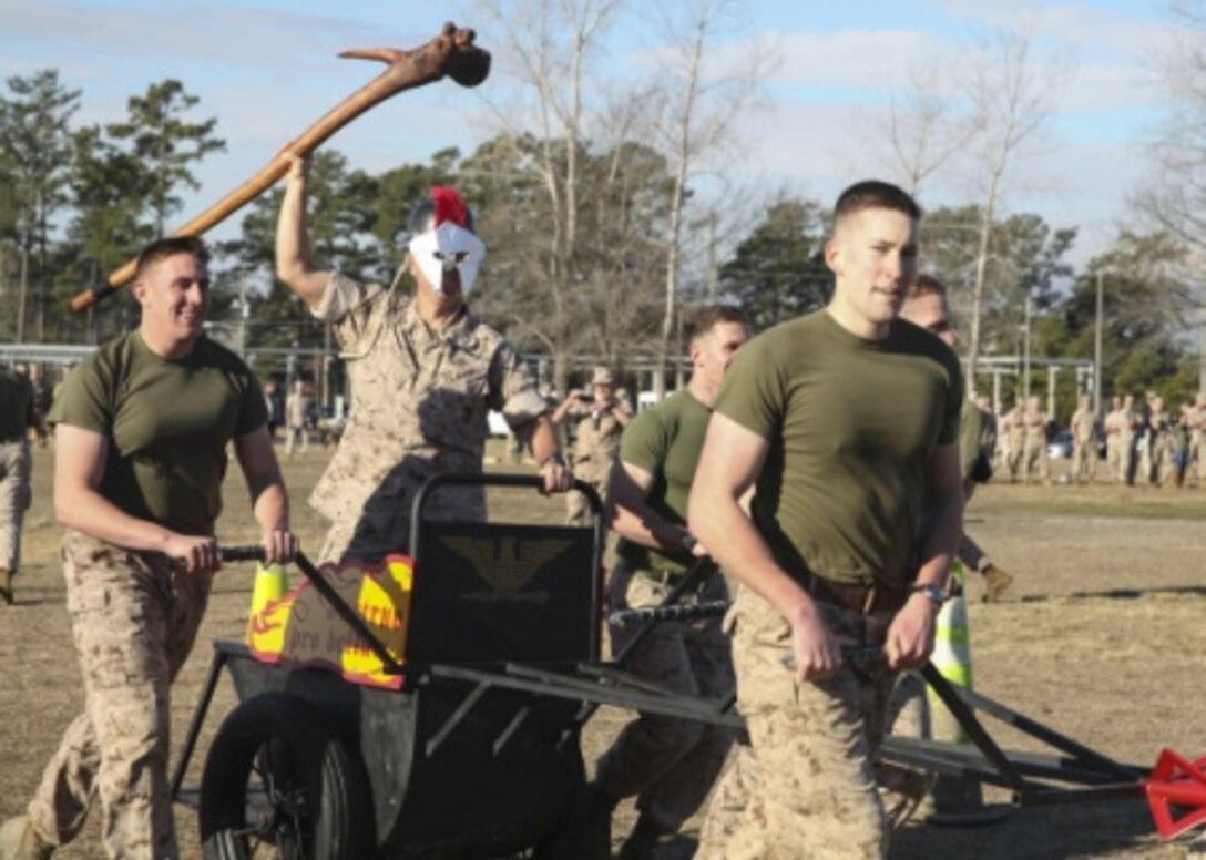 Colonel Scott Baldwin, the commanding officer of Marine Corps Engineer School and native of Newberg, Oregon, takes a victory lap with his team around the track in his chariot during the annual St. Patrick’s Day Engineer Field Meet, March 12, 2015, on Ellis Field at Courthouse Bay aboard Marine Corps Base Camp Lejeune, N.C. Engineers from across Camp Lejeune and New River Air Station came together to compete in 15 engineer-themed events in honor of the patron saint of engineers, St. Patrick. (U.S. Marine Corps photo by Cpl Michelle Reif/released)