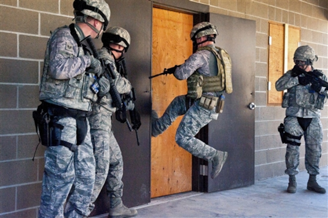 An airman attempts a jumping kick to breach a door to clear a building while participating in a course on Orchard Combat Training Center near Gowen Field, Idaho, March 10, 2015. The airmen are assigned to the Idaho National Guard's 124th Security Forces Squadron.