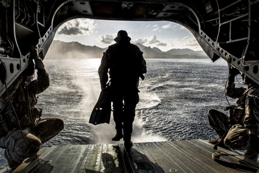 A soldier runs off the back of a CH-47F Chinook helicopter while conducting a simulated combat dive mission in the water off of Bellows Air Force Station in Waimanalo, Hawaii, March 16, 2015. The solder is assigned to 1st Special Forces Group, Joint Base Lewis-McChord.