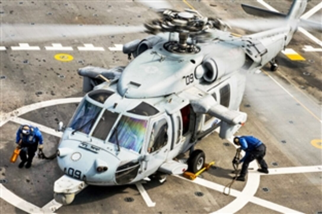 U.S. Navy sailors remove chalks and chains from an MH-60S Seahawk on the amphibious transport dock ship USS Green Bay in the East China Sea, March. 16, 2015. 