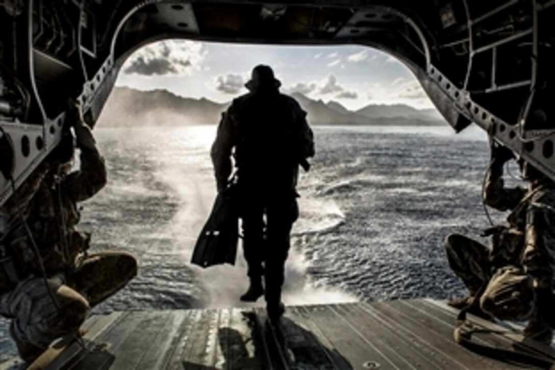 A soldier runs off the back of a CH-47F Chinook helicopter while conducting a simulated combat dive mission in the water off of Bellows Air Force Station in Waimanalo, Hawaii, March 16, 2015. The solder is assigned to 1st Special Forces Group, Joint Base Lewis-McChord.
