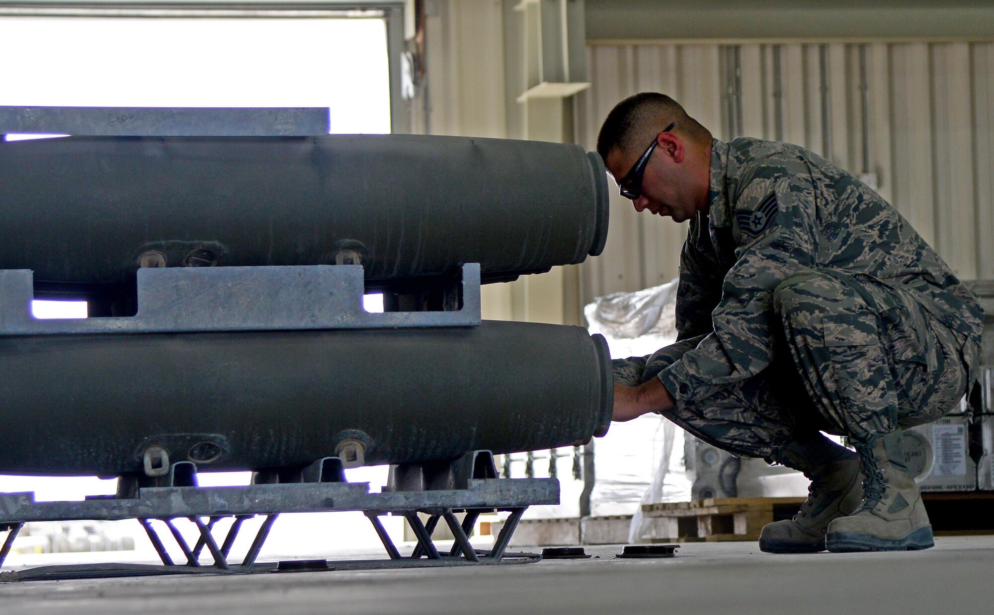 U.S. Air Force Staff Sgt. Richard Brooks, 379th Expeditionary Maintenance Squadron munitions technician, removes dust covers from a guided bomb unit body, March 13, 2015, at Al Udeid Air Base, Qatar. A GBU is a precision-guided munition designed to achieve greater accuracy.  Brooks is deployed from Ellsworth Air Force Base, S.D. (U.S. Air Force photo by Senior Airman Kia Atkins)