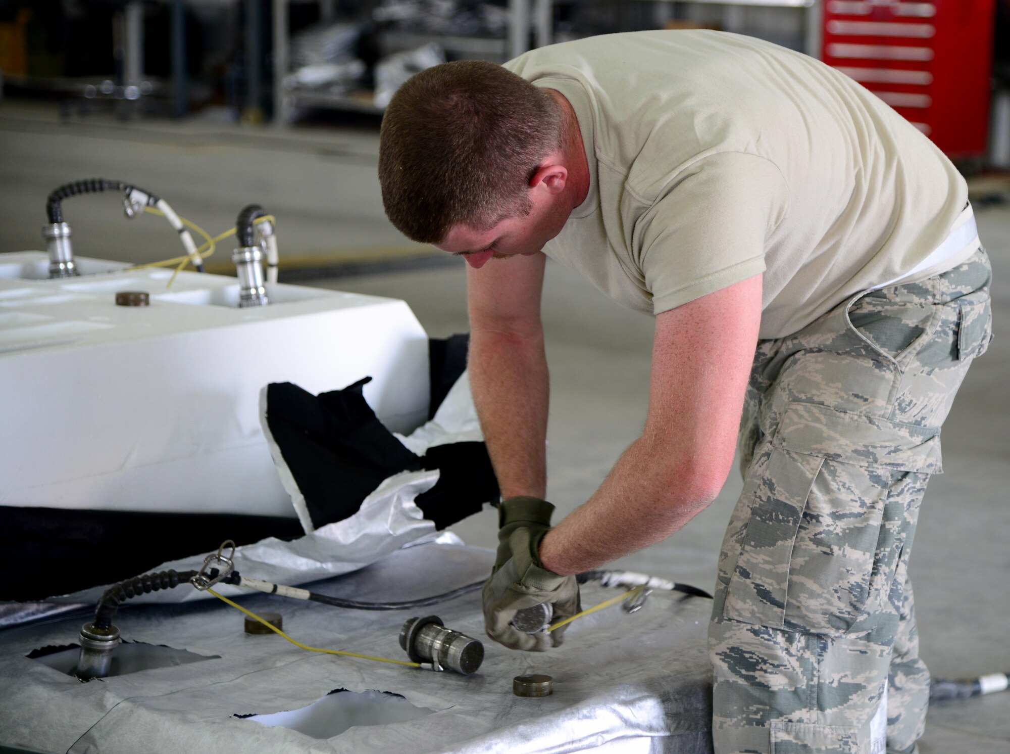 U.S. Air Force Airman 1st Class Steven Crane, 379th Expeditionary Maintenance Squadron conventional maintenance crew member, hooks fin kits up to a computer system, March 13, 2015, at Al Udeid Air Base, Qatar. The computer system checks the fin kits to ensure they are in good working order. Crane is deployed from Ellsworth Air Force Base, S.D. (U.S. Air Force photo by Senior Airman Kia Atkins)