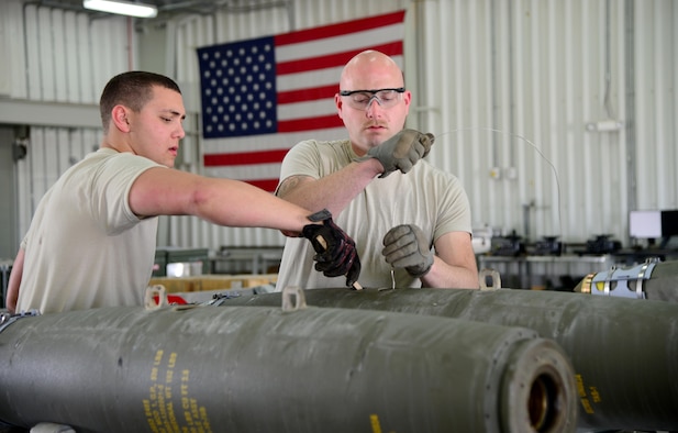 Ammo Airmen assigned to the 379th Expeditionary Maintenance Squadron load a fuse into a guided bomb unit at Al Udeid Air Base, Qatar, March 13, 2015, at Al Udeid Air Base, Qatar. A GBU is a precision-guided munition designed to achieve greater accuracy.  For every individual munition expenditure made by the B-1, Ammo Airmen build one—which can mean they are building anywhere between six and 12 Joint Direct Attack Munitions at a time.  (U.S. Air Force photo by Senior Airman Kia Atkins)