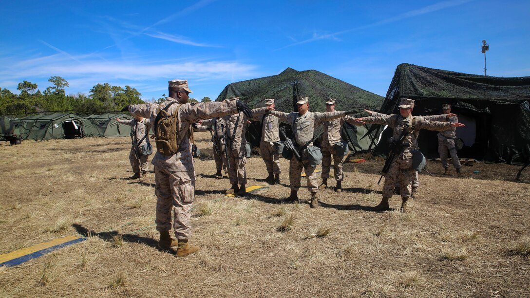 Gunnery Sgt. Ashton Benn, an assistant operations chief for II MEF Headquarters Group and Brooklyn, N.Y., native, teaches hand-and-arm signals during a MHG field exercise aboard Marine Corps Base Camp Lejeune, N.C., March 12-19, 2015. The purpose of the FEX was to allow the Marines the opportunity to test their skill sets and find areas of improvement. 