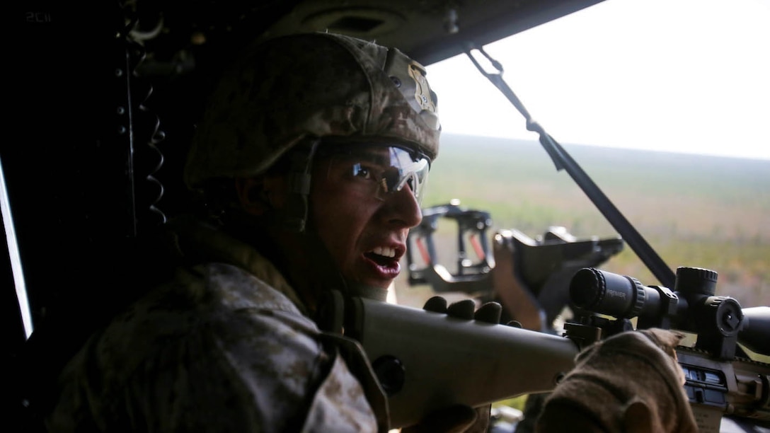 Corporal David Elliot, a sniper with Bravo Company, 2nd Reconnaissance Battalion and a native of Santa Rosa, Calif., communicates with his partner during the aerial sniper portion of the machine-gun and aerial sniper familiarization exercise at training area SR-8 aboard Camp Lejeune, N.C., March 12, 2015. Marines with the unit used M240B machine guns and M110 semi-automatic sniper systems during the aerial sniper and machine gun familiarization fire. 