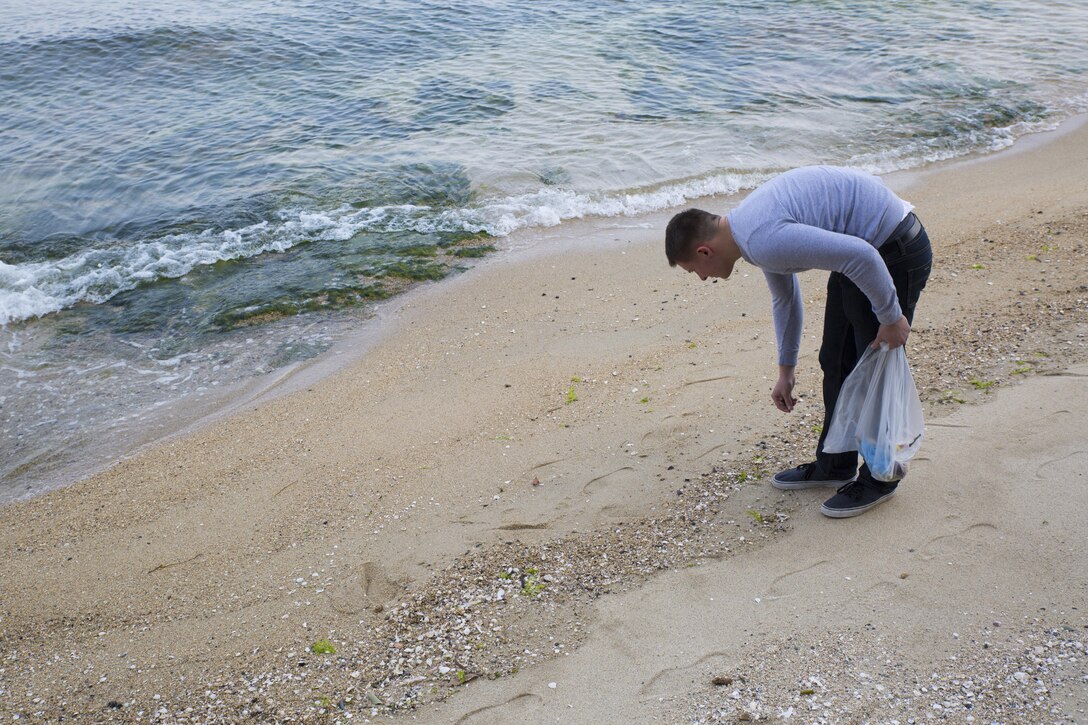 A service member with Marine Aviation Logistics Squadron 12 picks up trash at Tsuzu Beach during a community relations cleanup conducted by the Marine Aircraft Group Chaplain's Office abaord Marine Corps Air Station Iwakuni, Japan, March 13, 2014. Community relations events serve as an important tool in strengthening the bond between the U.S. and Japan. Major entities aboard station that conduct regular community relations events include the Marine Memorial Chapel, MAG-12 Chaplain's Office and the Single Marine Program.