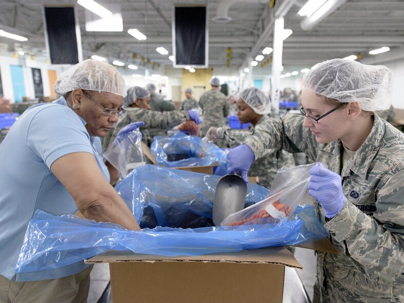 Senior Airman Susana Twilley, 71st Operations Support Squadron, Vance Air Force Base, Oklahoma, stands with Nick Collison, an Oklahoma City Thunder forward, March 9. Servicemembers from across the state teamed up with players from the Oklahoma City Thunder to package more than 20,000 pounds of food for Oklahoma families in 53 counties and 501 elementary schools. (U.S. Air Force photo \ David Poe)