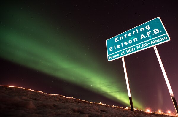 The lights along the flight line at Eielson Air Force Base, Alaska, shine under the Aurora Borealis, or Northern Lights, March 18, 2015. Eielson is home to RED FLAG-Alaska, a series of Pacific Air Forces commander-directed field training exercises for U.S. forces that provides joint offensive counter-air, interdiction, close air support, and large force employment training in a simulated combat environment. (U.S. Air Force photo by Staff Sgt. Shawn Nickel/Released)