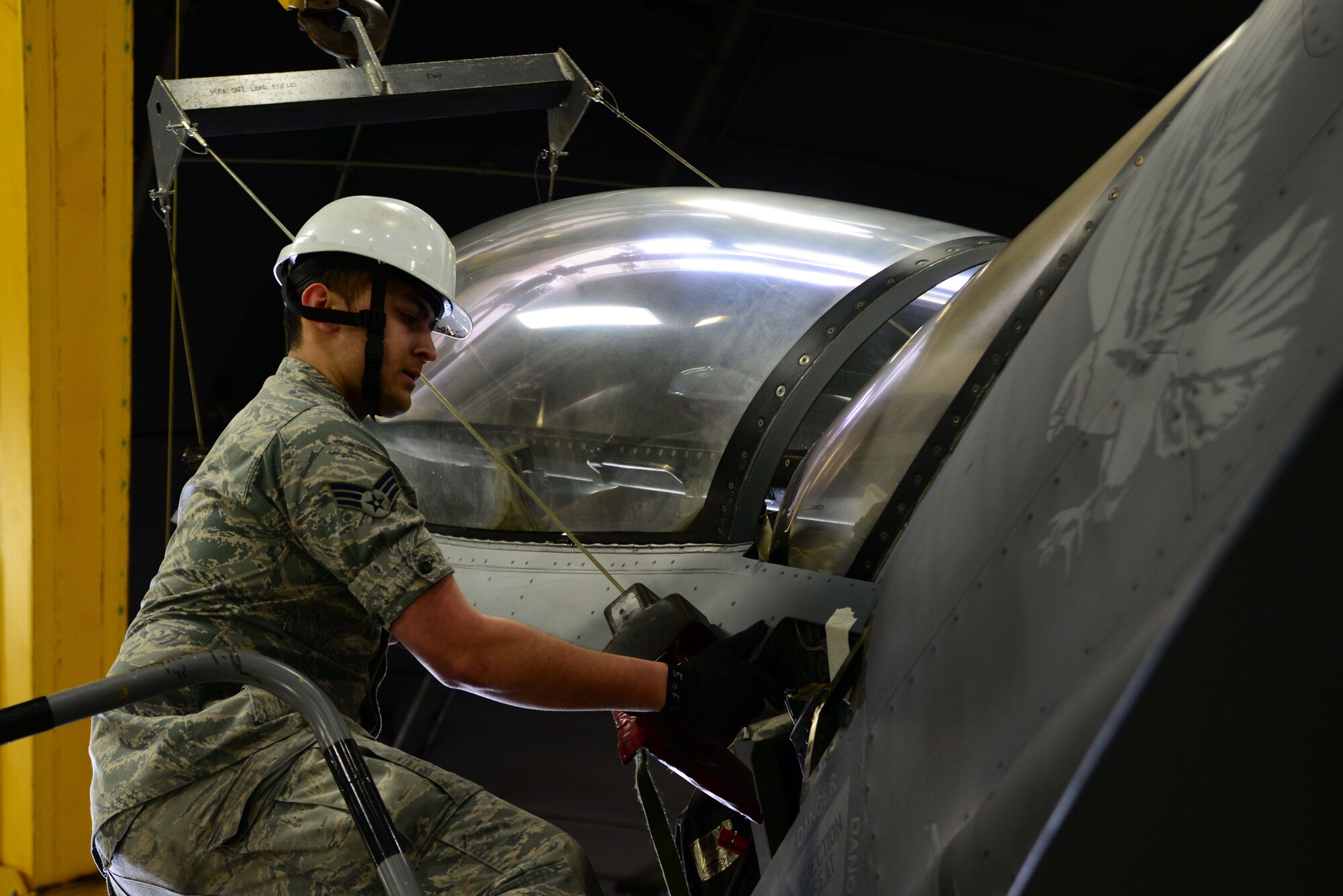 Senior Airman Jeffrey Bowen, 35th Maintenance Squadron egress systems, loosens the canopy of an F-16 Fighting Falcon on Feb. 20, 2015, at Misawa Air Base, Japan. As part of egress, Bowen and his co-workers specialize in F-16 Fighting Falcon seats and canopies, providing maintenance on them to ensure successful ejection for pilots. (U.S. Air Force photo by Staff Sgt. Derek VanHorn)