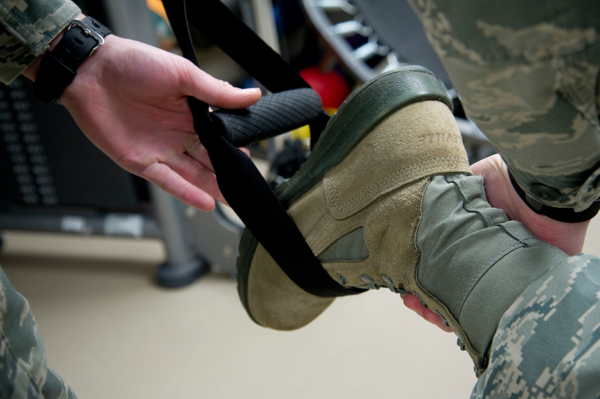 Staff Sgt. Sean Devereaux, 92nd Medical Operations Squadron physical therapy craftsman, places the foot of Master Sgt. Dawn Traurig, 92nd MDOS superintendent, into the handle of a resistance training band March 16, 2015, at Fairchild Air Force Base, Wash. The resistance training bands have many uses as well as helping patients of physical therapy, they are also useful for at home body weight workouts. (U.S. Air Force photo/Airman 1st Class Nicolo J. Daniello)