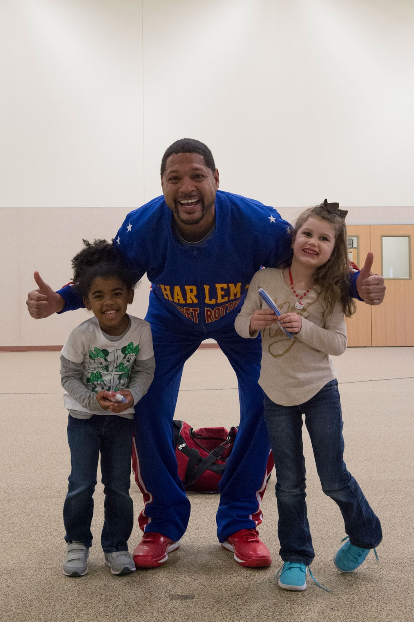 Harlem Globetrotter Handles Franklin interacts with Dalainie Simon, 4, left, and Braelynne Ryan, 5, while visiting Illa School Age Program children on Joint Base Elmendorf-Richardson to discuss bullying prevention, March 17, 2015. Known worldwide as the "Ambassadors of Goodwill"™, the iconic Harlem Globetrotters presented the community outreach program, "The ABCs of Bullying Prevention," in an effort to impact schools and communities around the world as well as and provide tools that kids can use on a daily basis to reduce bullying. (U.S. Air Force photo/Alejandro Pena)