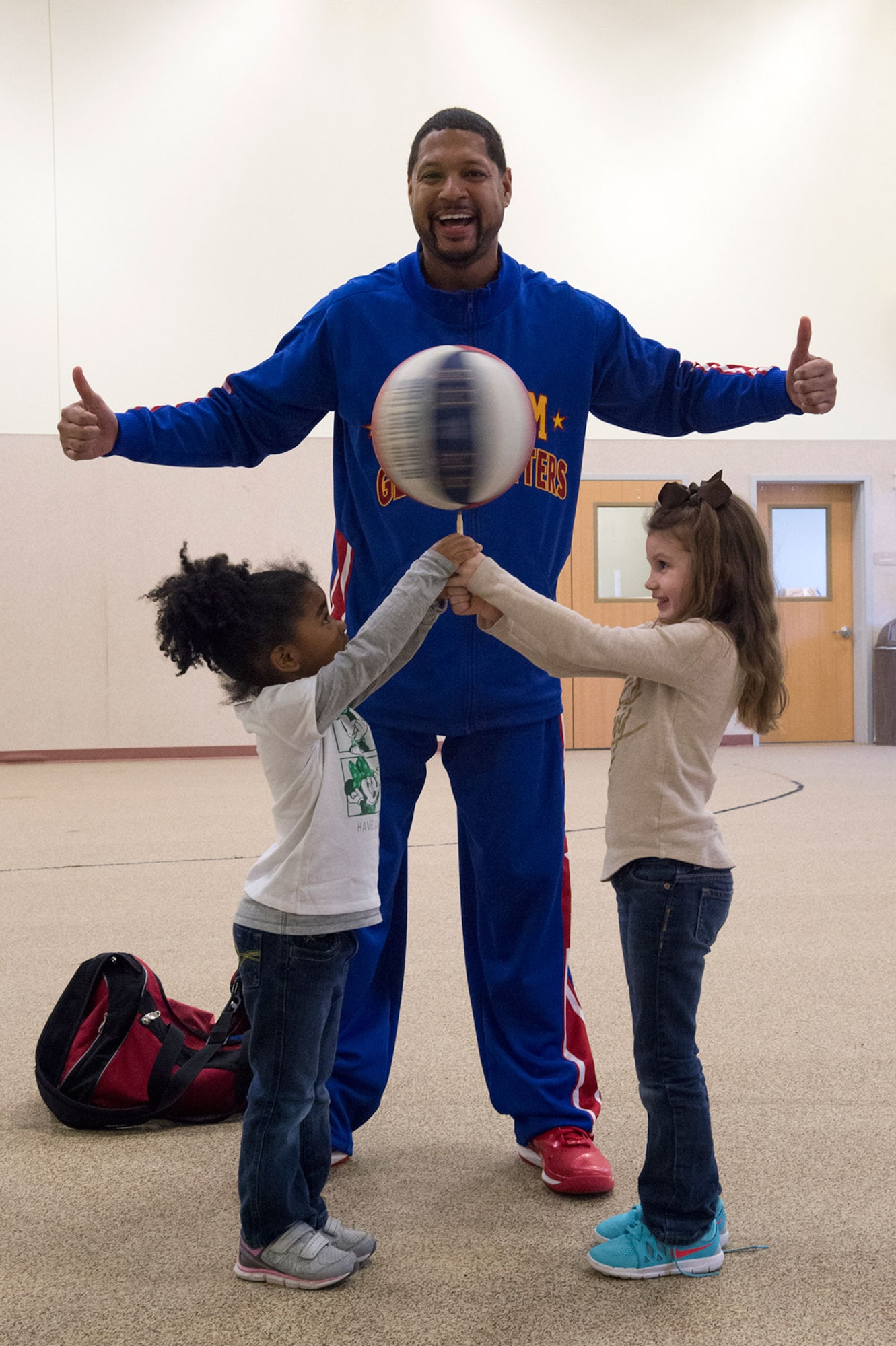 Harlem Globetrotter Handles Franklin interacts with Dalainie Simon, 4, left, and Braelynne Ryan, 5, while visiting Illa School Age Program children on Joint Base Elmendorf-Richardson to discuss bullying prevention, March 17, 2015. Known worldwide as the "Ambassadors of Goodwill"™, the iconic Harlem Globetrotters presented the community outreach program, "The ABCs of Bullying Prevention," in an effort to impact schools and communities around the world as well as and provide tools that kids can use on a daily basis to reduce bullying. (U.S. Air Force photo/Alejandro Pena)