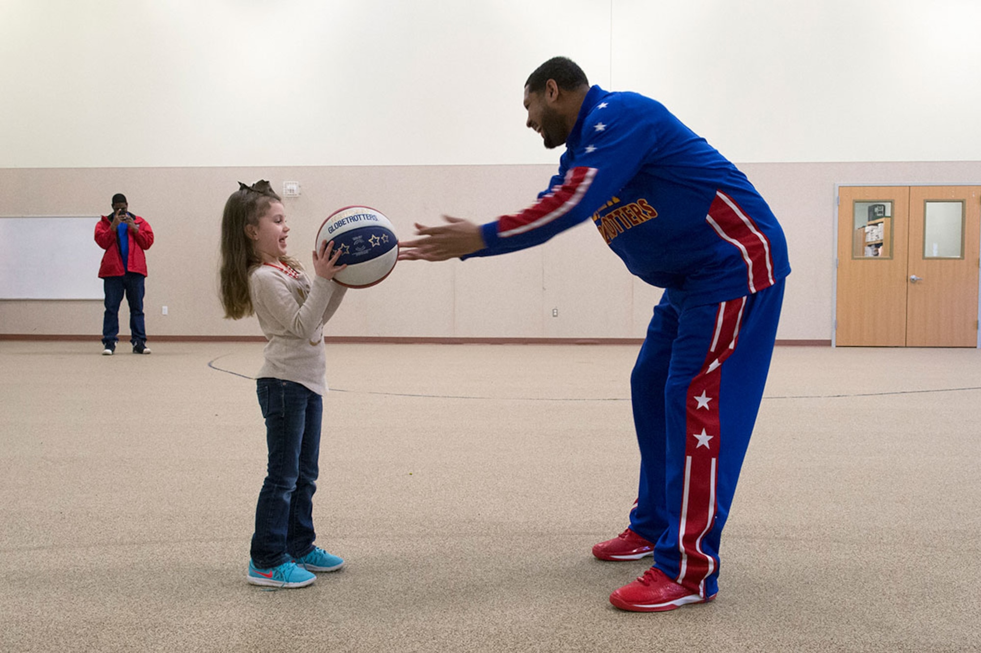 Harlem Globetrotter Handles Franklin interacts with Braelynne Ryan, 5, while visiting Illa School Age Program children on Joint Base Elmendorf Richardson to discuss bullying prevention, March 17, 2015. Known worldwide as the "Ambassadors of Goodwill"™, the iconic Harlem Globetrotters presented the community outreach program, "The ABCs of Bullying Prevention," in an effort to impact schools and communities around the world as well as and provide tools that kids can use on a daily basis to reduce bullying. (U.S. Air Force photo/Alejandro Pena)