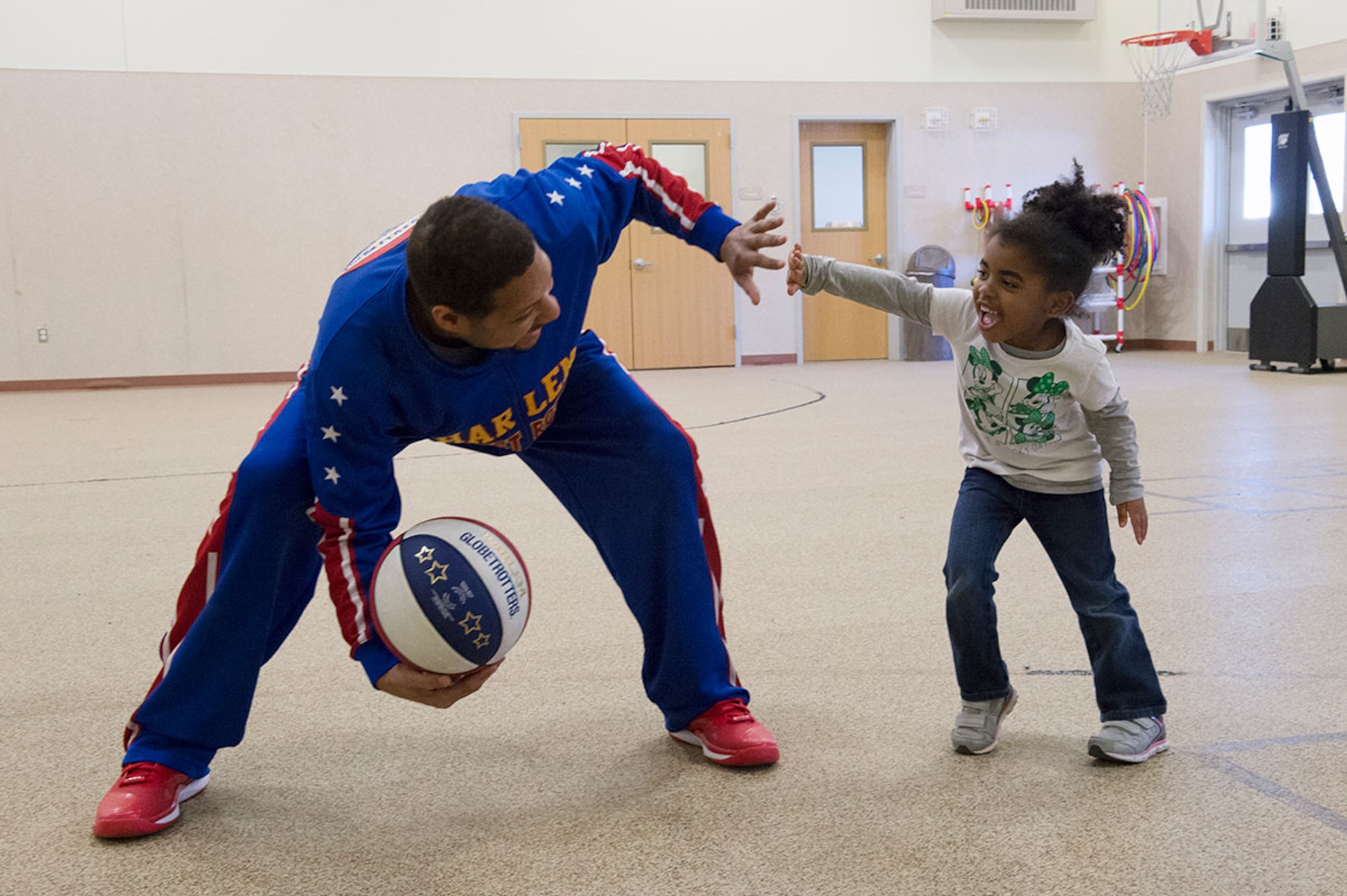 Harlem Globetrotter Handles Franklin interacts with Delainie Simon, 4, while visiting Illa School Age Program children on Joint Base Elmendorf-Richardson to discuss bullying prevention, March 17, 2015. Known worldwide as the "Ambassadors of Goodwill"™, the iconic Harlem Globetrotters presented the community outreach program, "The ABCs of Bullying Prevention," in an effort to impact schools and communities around the world as well as and provide tools that kids can use on a daily basis to reduce bullying. (U.S. Air Force photo/Alejandro Pena)