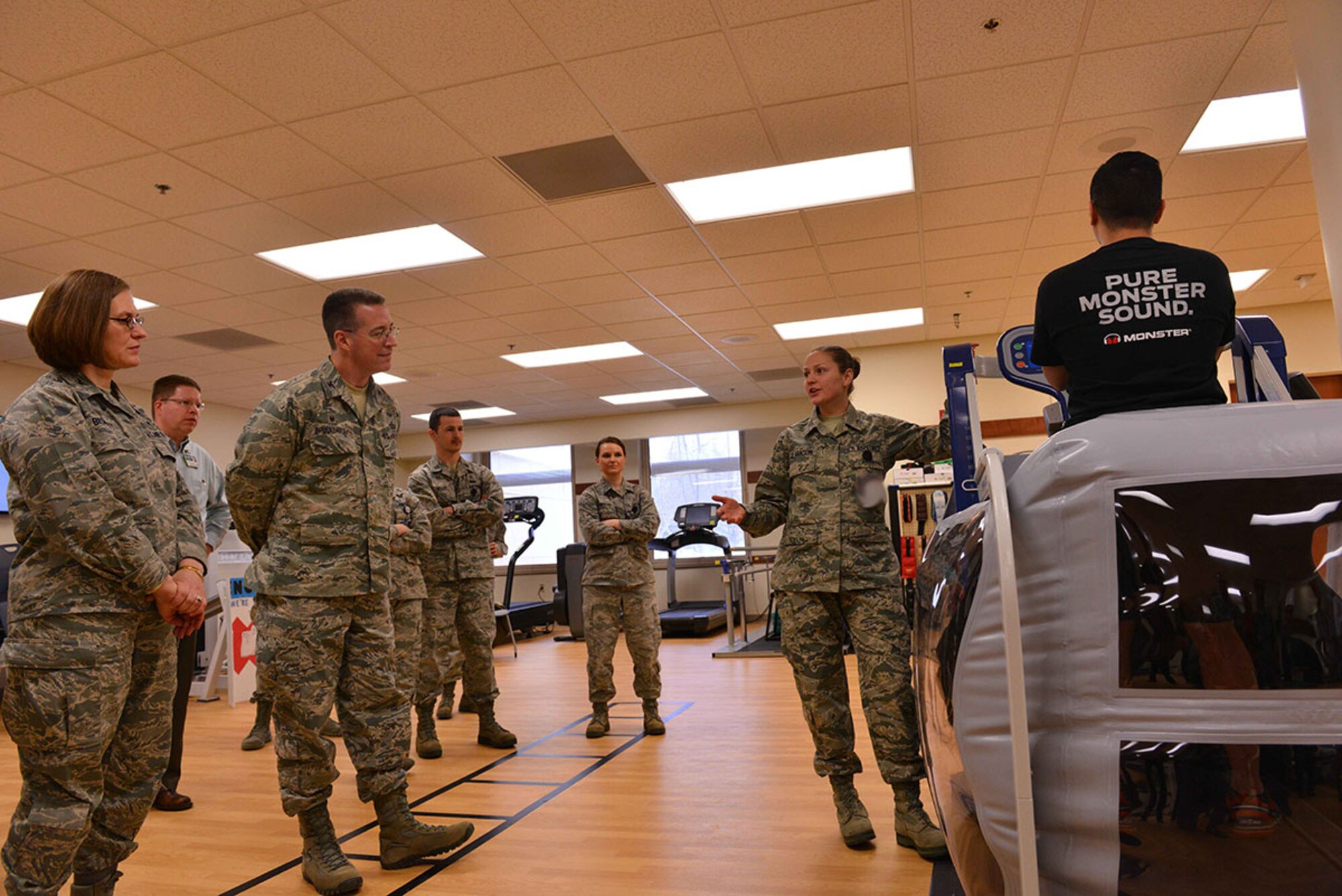 Senior Airman Jennifer Clarkson, a physical medicine technician with the  673d Medical Group physical therapy clinic, explains the features of a specialized treadmill to JBER leadership at the ribbon cutting ceremony for the clinic March 2, 2015. The ceremony was held in honor of the recent renovations to the clinic which increased operational space by 500 square feet and added several new pieces of equipment. (U.S. Air Force Photo Illustration/Airman 1st Class Kyle Johnson)