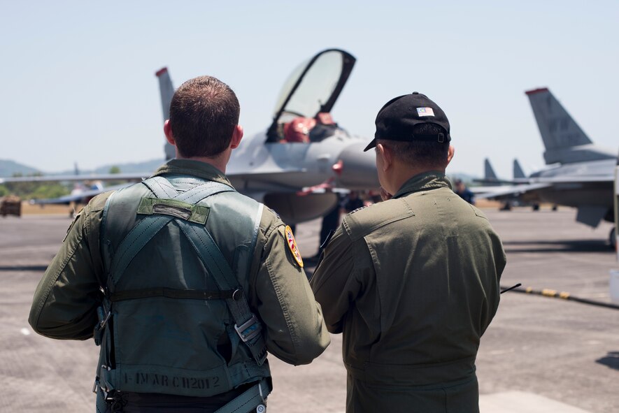Capt. Austin Brown, a Pacific Air Forces??? Demonstration Team pilot reviews his F-16 Fighting Falcon demonstration with a member of the Langkawi International Maritime and Aerospace Exhibition crew, March 16, 2015. Defense Department participation in the LIMA 15 airshow strengthens military-to-military relationships and underscores the cooperation agreements between the U.S. and Malaysia. (U.S. Air Force photo by 1st Lt. Elias Zani/Released)