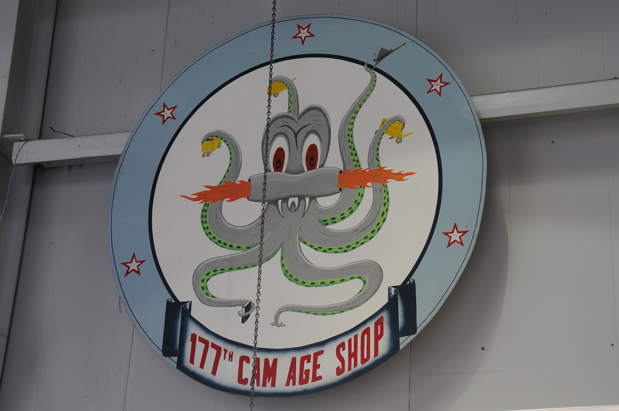 A picture of the 177th Aerospace Ground Equipment squadron's painting of an octopus, displayed holding multiple types of ground equipment in each tentacle.