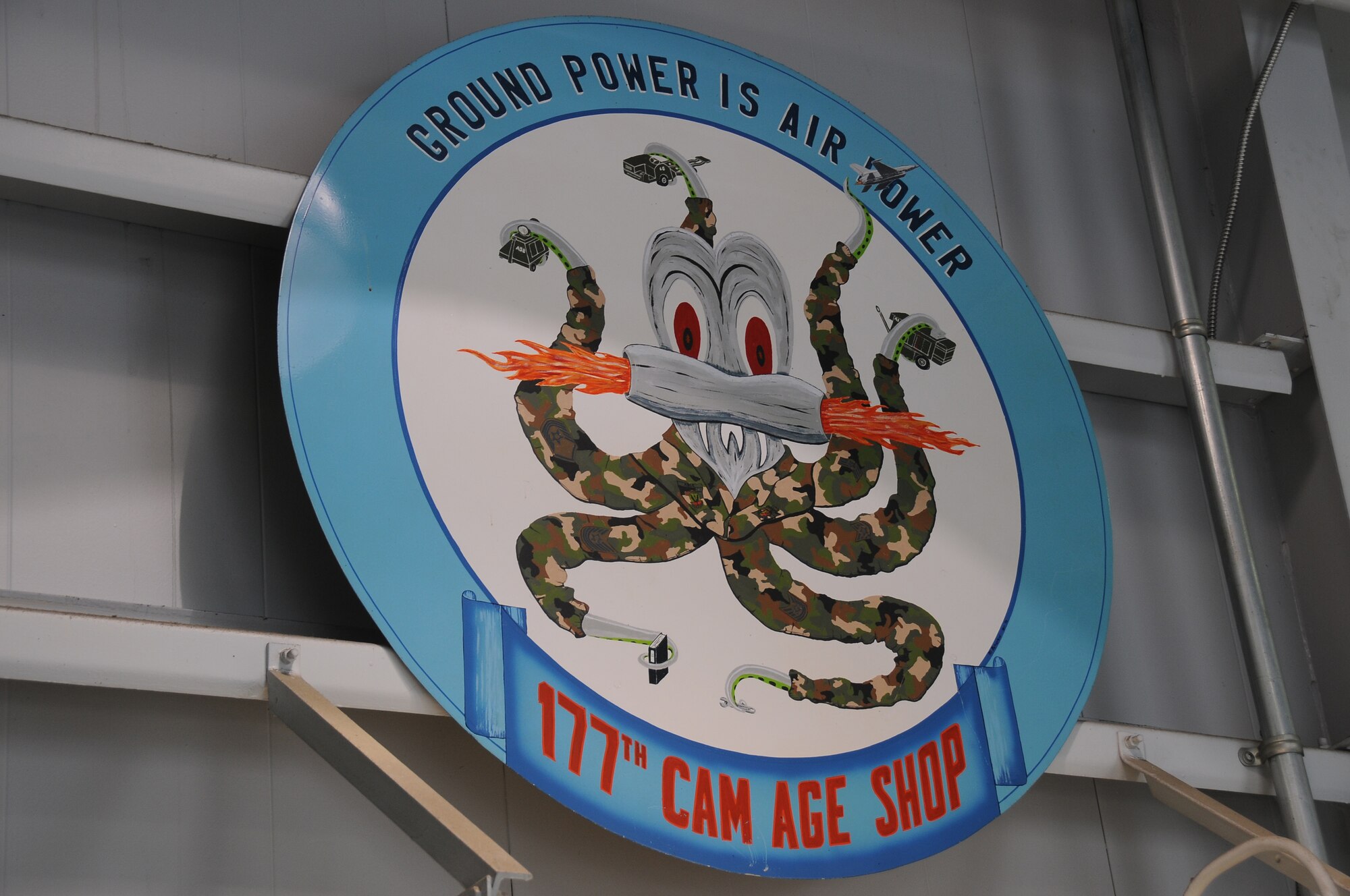 A picture of the 177th Aerospace Ground Equipment squadron's painting of an octopus, displayed holding multiple types of ground equipment in each tentacle.