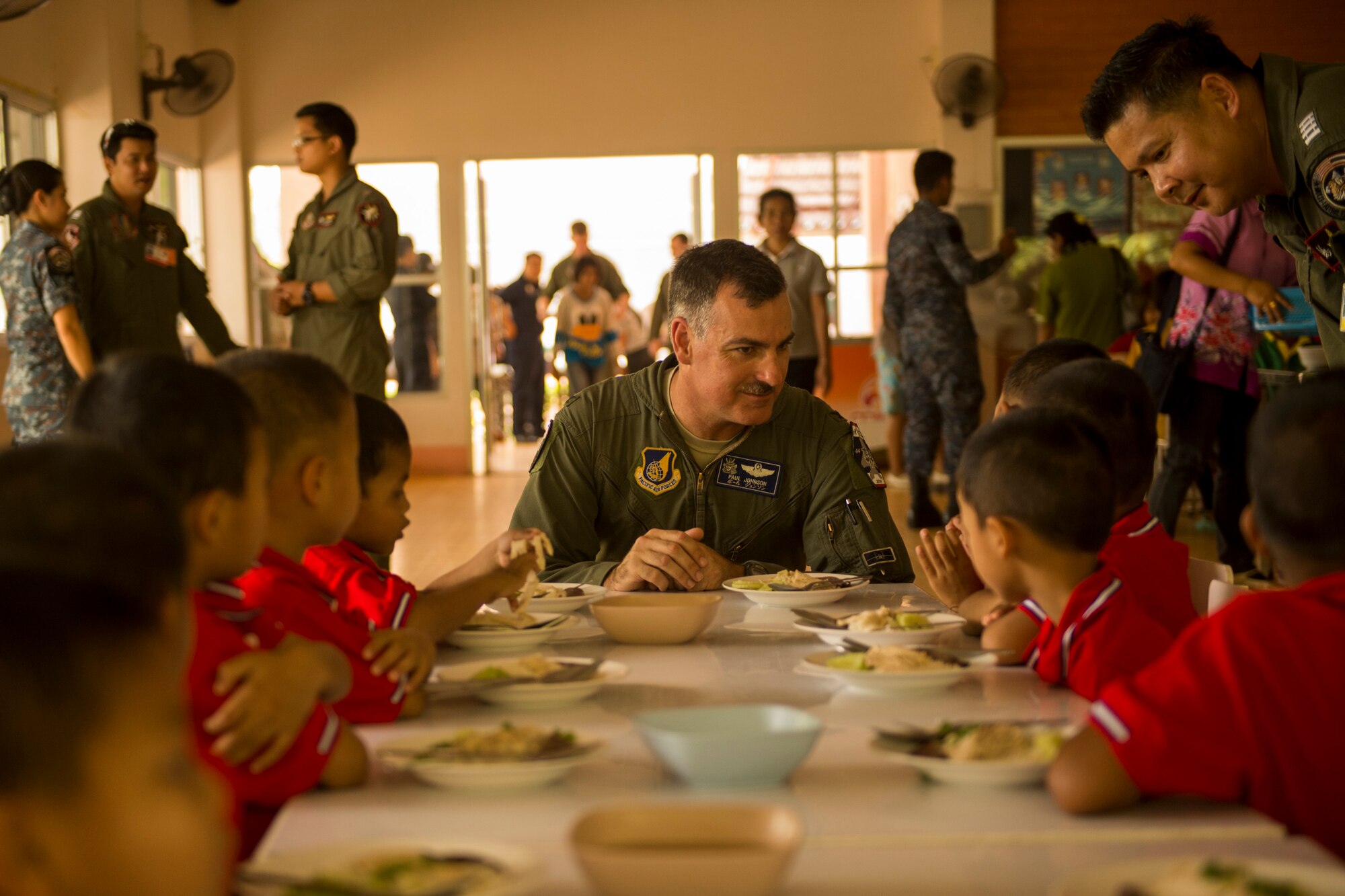 U.S. Air Force Col. Paul Johnson, Exercise Cope Tiger commander, serves lunch to children at a local boys and girls shelter in Udon Thani, Thailand, March 18, 2015. CT15 includes 22 total flying units and over 1390 personnel from three countries and continues the growth of strong, interoperable, and beneficial relationships within the Asia-Pacific region through integration of airborne and land-based command and control assets.(U.S. Air Force photo by Airman 1st Class Taylor Queen/Released)