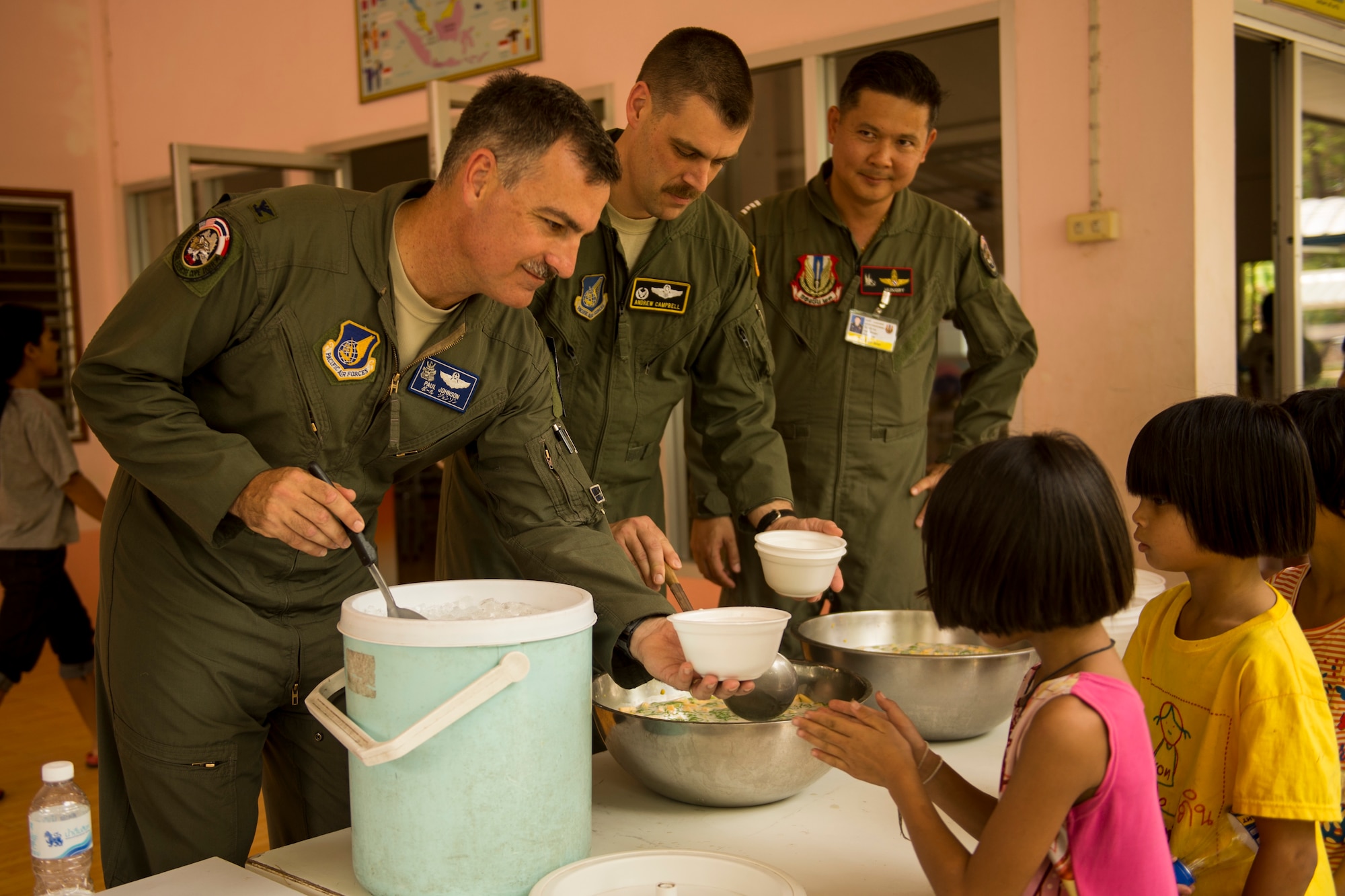 U.S. Air Force Col. Paul Johnson, Exercise Cope Tiger commander, serves lunch to children at a local boys and girls shelter in Udon Thani, Thailand, March 18, 2015. CT15 includes 22 total flying units and over 1390 personnel from three countries and continues the growth of strong, interoperable, and beneficial relationships within the Asia-Pacific region through integration of airborne and land-based command and control assets.(U.S. Air Force photo by Airman 1st Class Taylor Queen/Released)