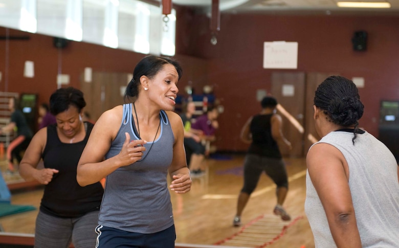 Nikki Harris (center) Warrior Fitness Center fitness instructor, laughs with one of the participants during a Warrior Challenge Soar into Shape class at the fitness center on Nellis Air Force Base, Nev., Feb. 25, 2015. Harris, had the particpants perform agility ladder drills as well as several bodyweight exercises. (U.S. Air Force photo by Airman 1st Class Rachel Loftis)