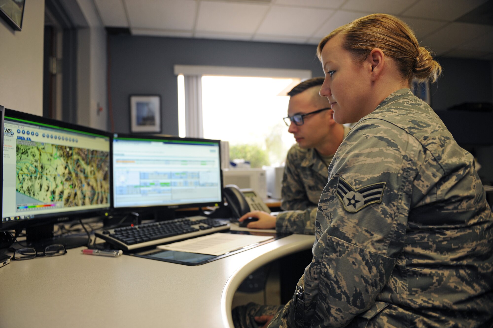 U.S. Air Force Senior Airman Amanda Boone, 355th Operational Support Squadron weather forecaster, instructs Airman 1st Class Blake Noll, 355th OSS weather forecaster, how to read current radar images at Davis-Monthan Air Force Base, Ariz., March 19, 2015. Both Airmen recently witnessed a car accident in the city of Tucson, Ariz., where Boone administered self-aid buddy care to a victim involved.  (U.S. Air Force photo by Airmen 1st Class Cheyenne Morigeau/Released)