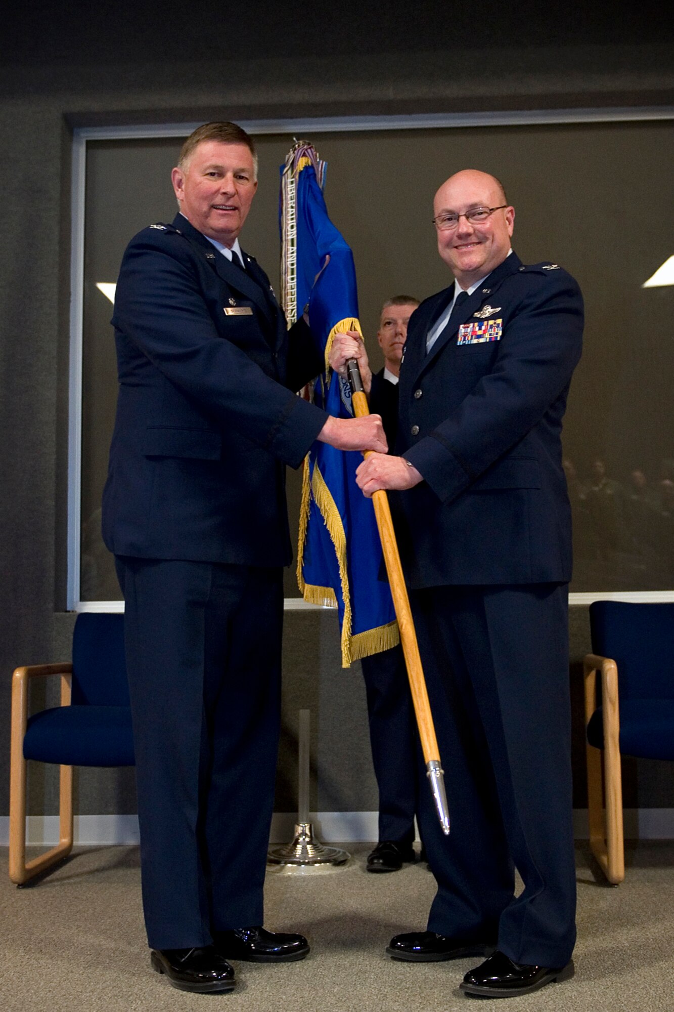 Col. Mark Sigler, 434th Operations Group commander, receives the 434th OG guidon from Col. Doug Schwartz, 434th Air Refueling Wing commander, during an assumption of command ceremony at Grissom Air Reserve Base, Ind., March 7, 2015. As the 434th OG commander, Sigler is responsible for the day-to-day operational training and overall management of two KC-135R flying squadrons and an operations support squadron. (U.S. Air Force photo/Tech. Sgt. Benjamin Mota)
