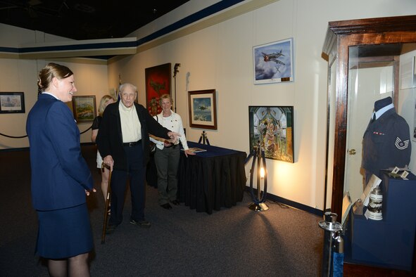 Bernhard Molter, center, was stationed at Tempelhof, the American site of the Berlin Airlift. He saw flights taking off or landing every three minutes for the next year. His daughter, A ir Force Reserve Command’s Lt. Col. Kelli Molter, surprised her father and mother, Bernhard and Marilyn Molter, at the Museum of Aviation’s art gallery with a display case and a picture book. (U.S. Air Force photo by Tommie Horton)