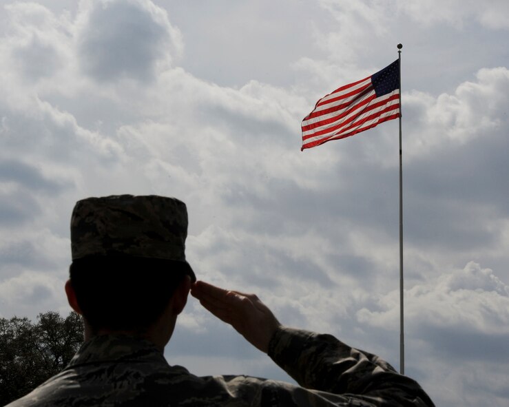 Airman 1st Class Jayson Burns, 2nd Bomb Wing Public Affairs broadcaster, renders a salute to the U.S. flag on Barksdale Air Force Base, La., March, 18, 2015. According to Air Force Instruction 34-1201, “Protocol”, if Reveille or Retreat is played, followed by "To the Color" or the national anthem, military members are required to render proper courtesies. (U.S. Air Force photo/ Senior Airman Jannelle Dickey) 