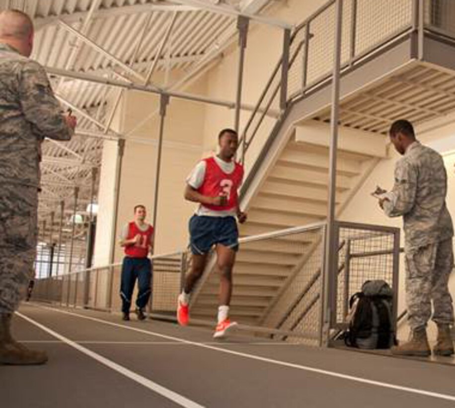 U.S. Air Force physical fitness assessment monitors log laps during a one and a half mile run at the Bell Fitness Center on Barksdale Air Force Base, La., Mar. 7, 2015. Airmen must complete a one and a half mile run, a minimum number of pushups, and sit-ups in one minute, as well as meet an abdominal circumference measured to pass the bi-annual or annual fitness test. (U.S. Air Force photo by Master Sgt. Jeff Walston/Released)    