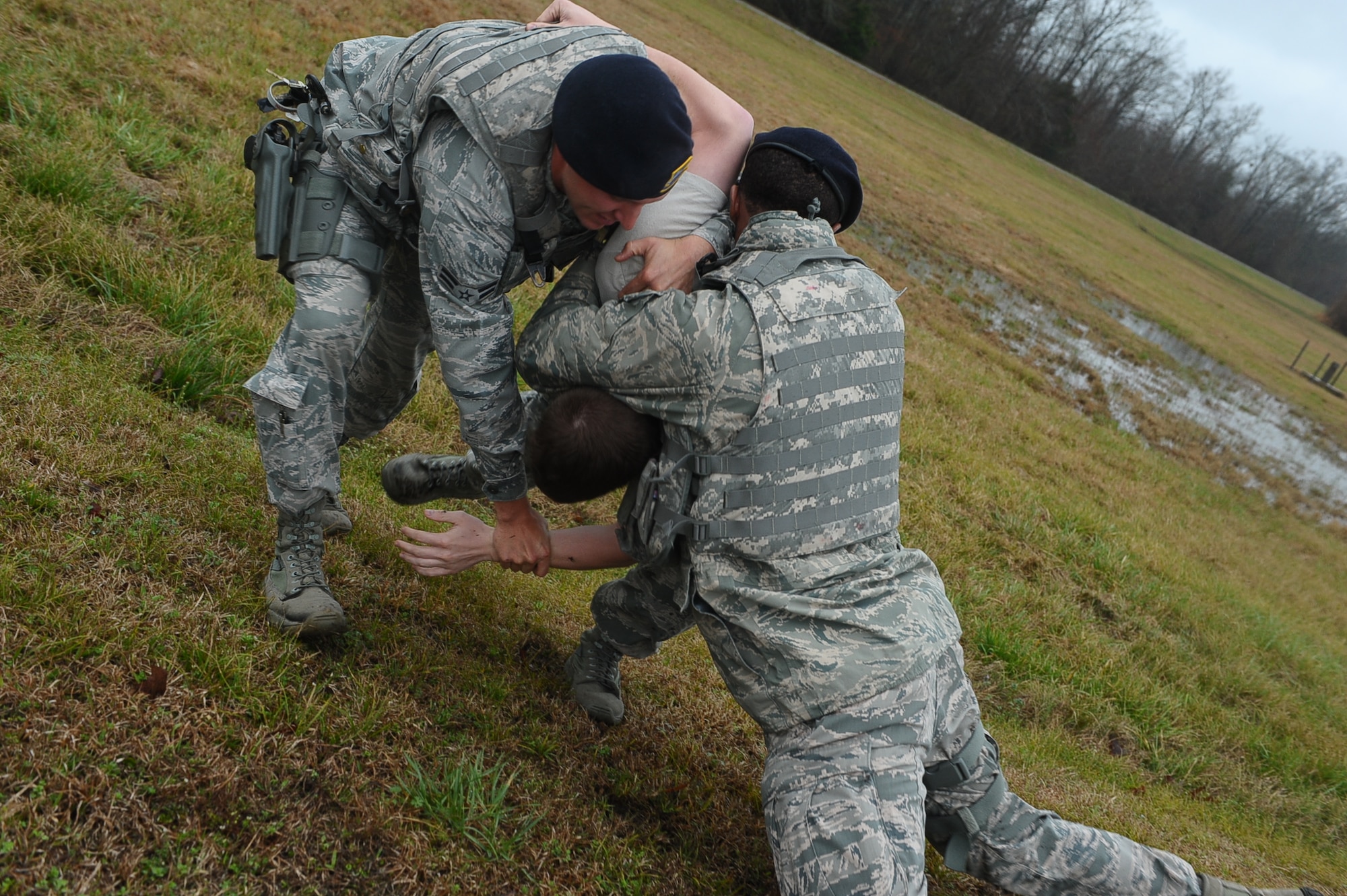Defenders tackle a suspect to the ground after he refused to get back into his vehicle and was demonstrating aggressive behavior during an exercise March 13 on Columbus Air Force Base, Miss. The suspect tried to run and evade the defenders but was quickly chased down. (U.S. Air Force photo/Airman Daniel Lile)