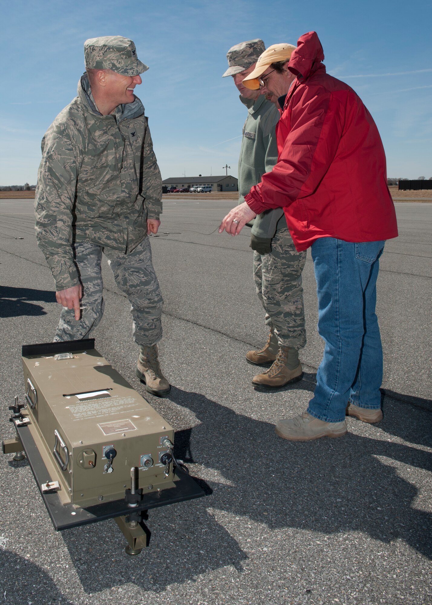 Col. Michael Grismer, 436th Airlift Wing commander, left, talks with Pat Cox, 436th Civil Engineer Squadron foreman, right, and Master Sgt. James Justice, 436th CES NCO in charge of the electric shop, March 18, 2015, at Dover Air Force Base, Del. Cox and Justice are explaining how a Precision Approach Path Indicator (PAPI) works. (U.S. Air Force photo/Airman 1st Class Zachary Cacicia)