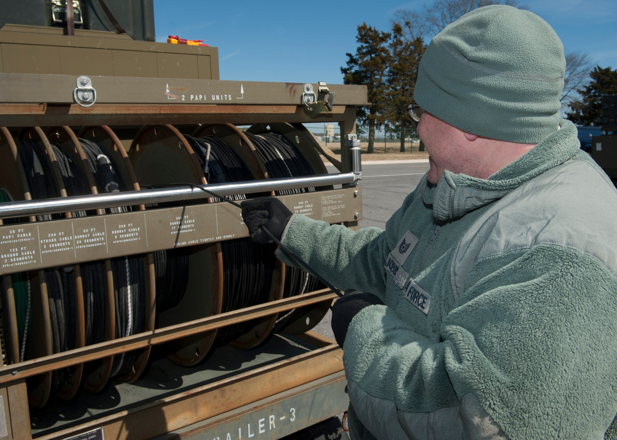 Tech. Sgt. Michael Jobin, 436th Civil Engineer Squadron electrician, guides an electrical cable as it is being unraveled March 18, 2015, at Dover Air Force Base, Del. The Emergency Airfield Lighting System has just been returned to Dover AFB from Minot AFB, N.D. (U.S. Air Force photo/Airman 1st Class Zachary Cacicia)