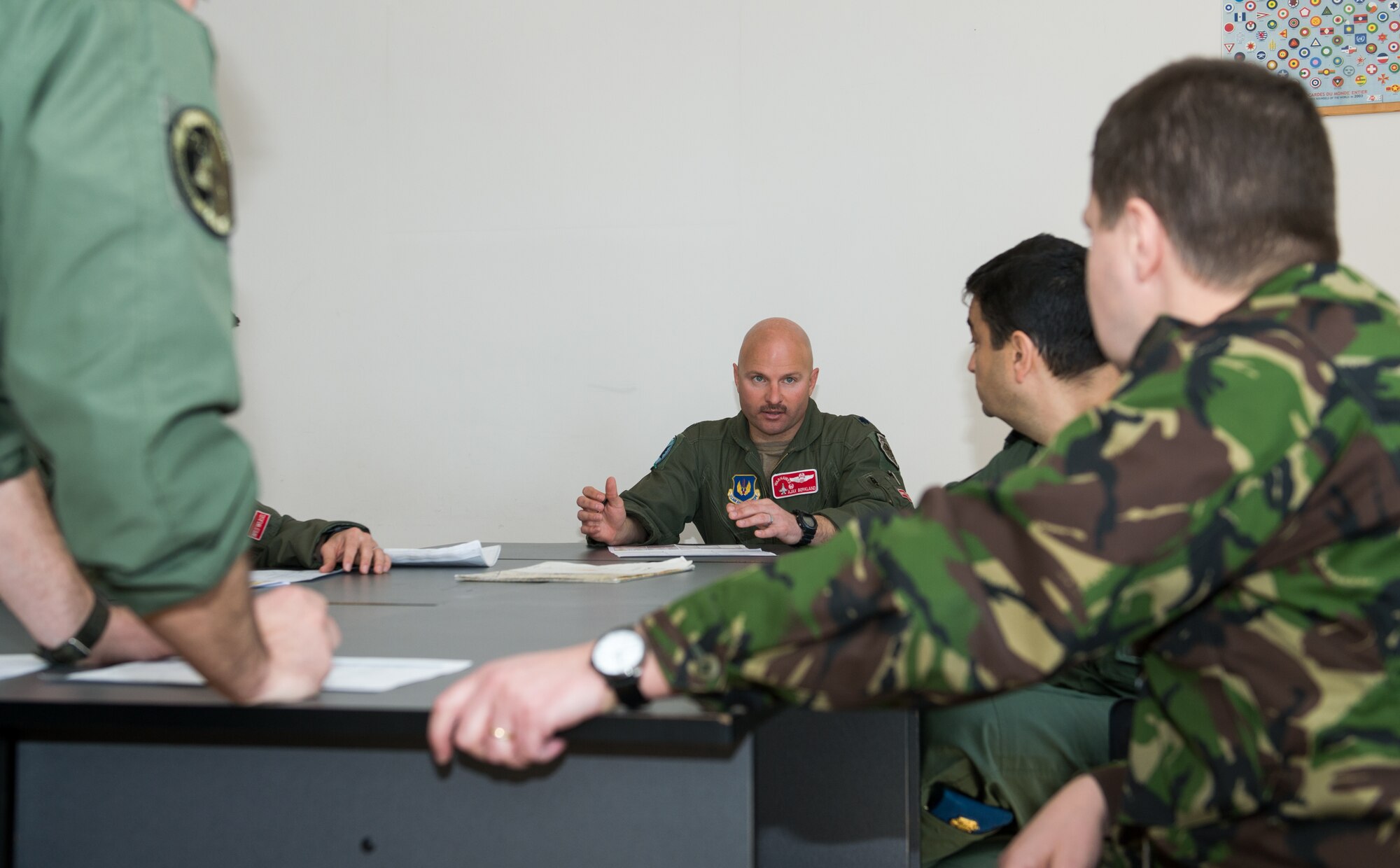Lt. Col. David Berkland, 480th Fighter Squadron commander, talks with Romanian counterparts prior to an F-16CJ Fighting Falcon versus MiG-21 training event at Campia Turzii, Romania, March 17, 2015. U.S. and Romanian airmen conducted tactical intercepts during the bilateral Dacian Warhawk mission. (U.S. Air Force photo/Staff Sgt. Armando A. Schwier-Morales)
