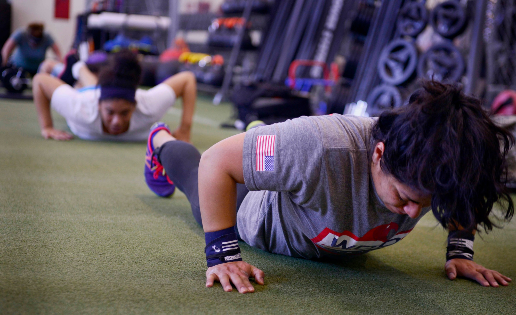 Participants of CrossFit Aviano finish 100 push-ups during a workout Mar. 18, 2015, at Aviano Air Base, Italy.  The push-ups were part of a CrossFit routine where individuals focused on stamina, endurance and strength building, utilizing high intensity workouts.   The classes are free of charge and are instructed by a certified trainer.  (U.S. Air Force photo by Senior Airman Abbey Whittaker/Released)