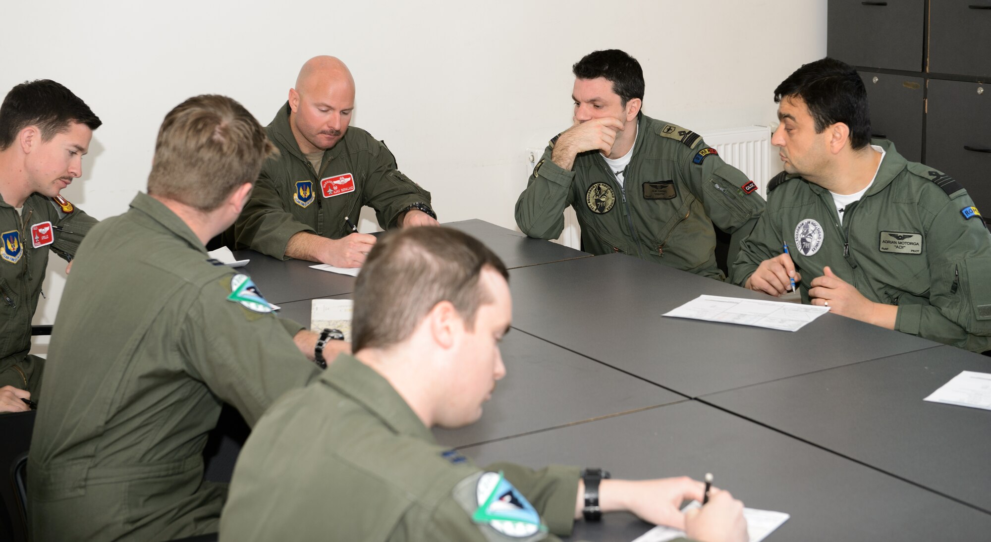 Pilots from the U.S. and Romanian air forces go over pre-flight paperwork and tactics at Campia Turzii, Romania, March 17, 2015. The pilots practiced air-to-air tactics during the Dacian Warhawk mission. The training is designed to improve the interoperability between U.S. and Romanian airmen. (U.S. Air Force photo/ Staff Sgt. Armando A. Schwier-Morales)
