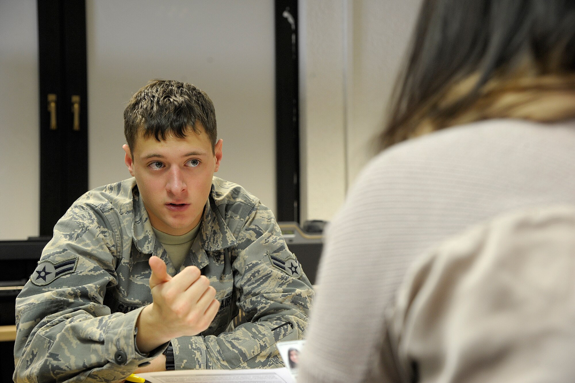 Airman 1st Class Collin Sams, 786th Force Support Squadron ID card apprentice, speaks with a customer about her civilian ID card at the 786th FSS Customer Support office on Ramstein Air Base, Germany, March 12, 2015. The 786th Customer Support ID card section issues ID cards to military members, Department of Defense civilians, dependents and local nationals. (U.S. Air Force photo/Senior Airman Timothy Moore)