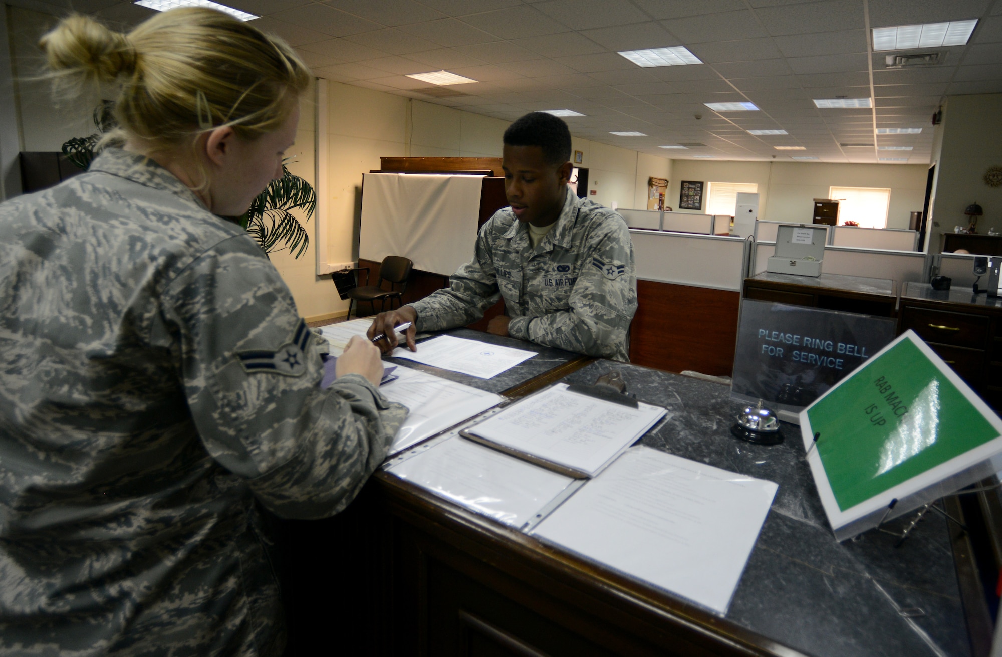 Airman 1st Class Robert Phillips III, 39th Security Forces Squadron Pass and Registration Section representative, assists a customer March 10, 2015, at Incirlik Air Base, Turkey. The American pass and registration office on base works with the Turkish pass and registration office for many different items concerning base access including friend and family gate passes for visiting. (U.S. Air Force photo by Staff Sgt. Caleb Pierce/Released)