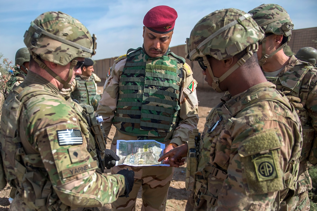 U.S. soldiers point out training locations on a map to an Iraqi army captain on Camp Taji, Iraq, March 12, 2015. The soldiers are assigned to the 82nd Airborne Division's Company C, 2nd Battalion, 505th Parachute Infantry Regiment, 3rd Brigade Combat Team. The Iraqi soldiers are training with U.S. soldiers for deployment to northern Iraq.