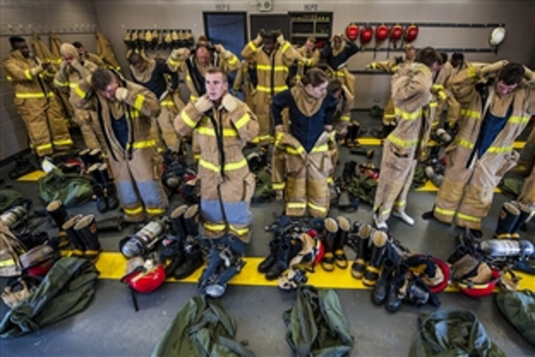 Sailors put on fire protection equipment to prepare for a shipboard firefighting training at the Surface Warfare Officer's School on Joint Base Pearl Harbor-Hickam in Pearl Harbor, Hawaii, March 18, 2015. 
