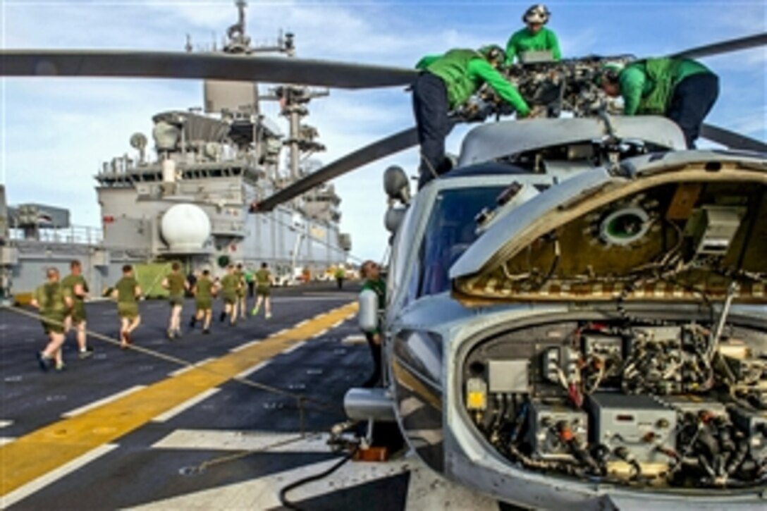 Sailors perform maintenance on an MH-60S Seahawk helicopter on the flight deck of the amphibious assault ship USS Essex in the Pacific Ocean, March 17, 2015. The sailors are assigned to Helicopter Sea Combat Squadron 21.

