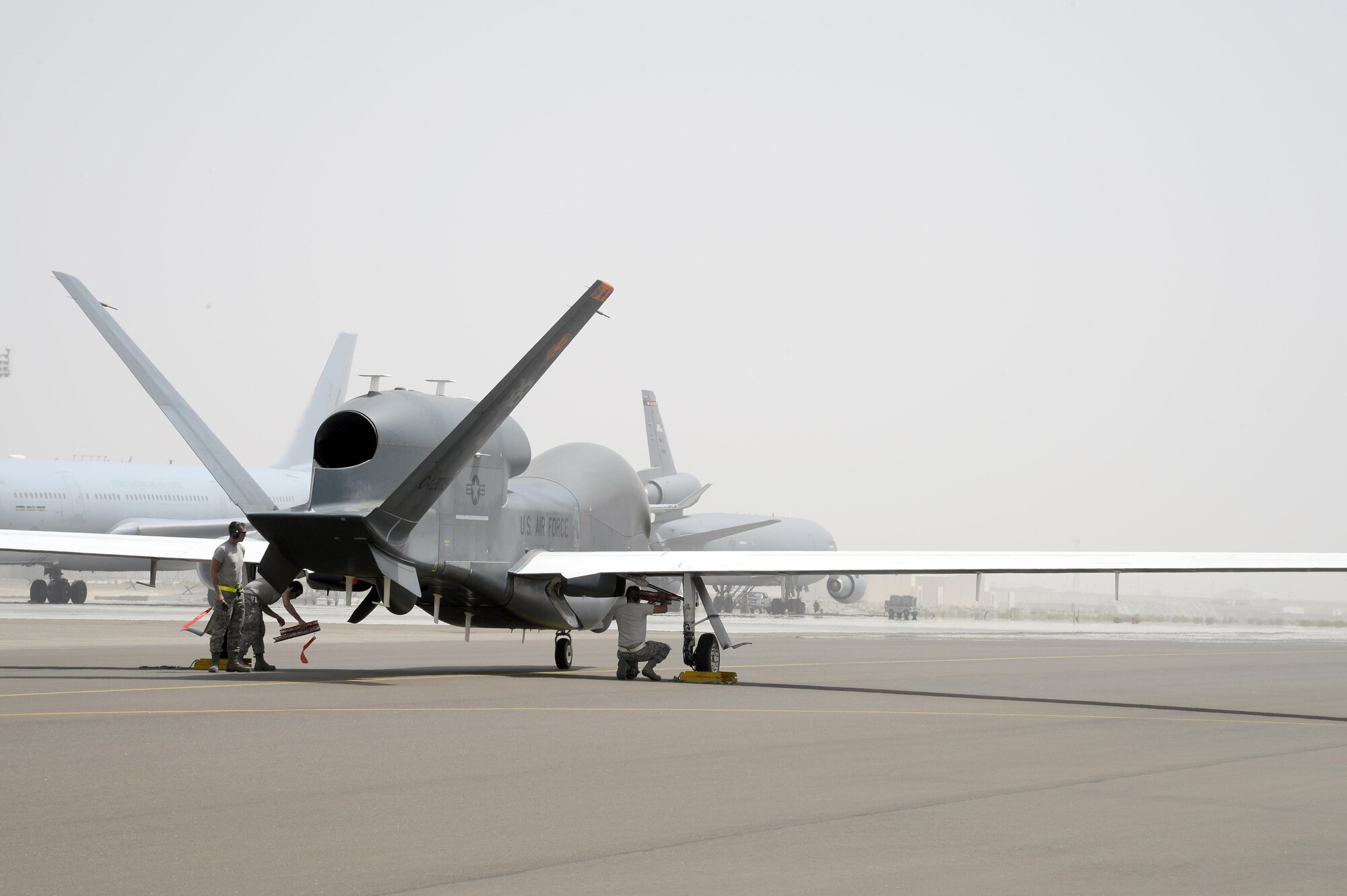 Airmen with the Hawk Aircraft Maintenance Unit prepare a RQ-4 Global Hawk for towing after it landed from a 30.5 hour flight at an undisclosed location in Southwest Asia Mar. 8, 2015. The Global Hawk has been deployed operationally to support overseas contingency operations since November 2001. (U.S. Air Force photo/Tech. Sgt. Marie Brown)
