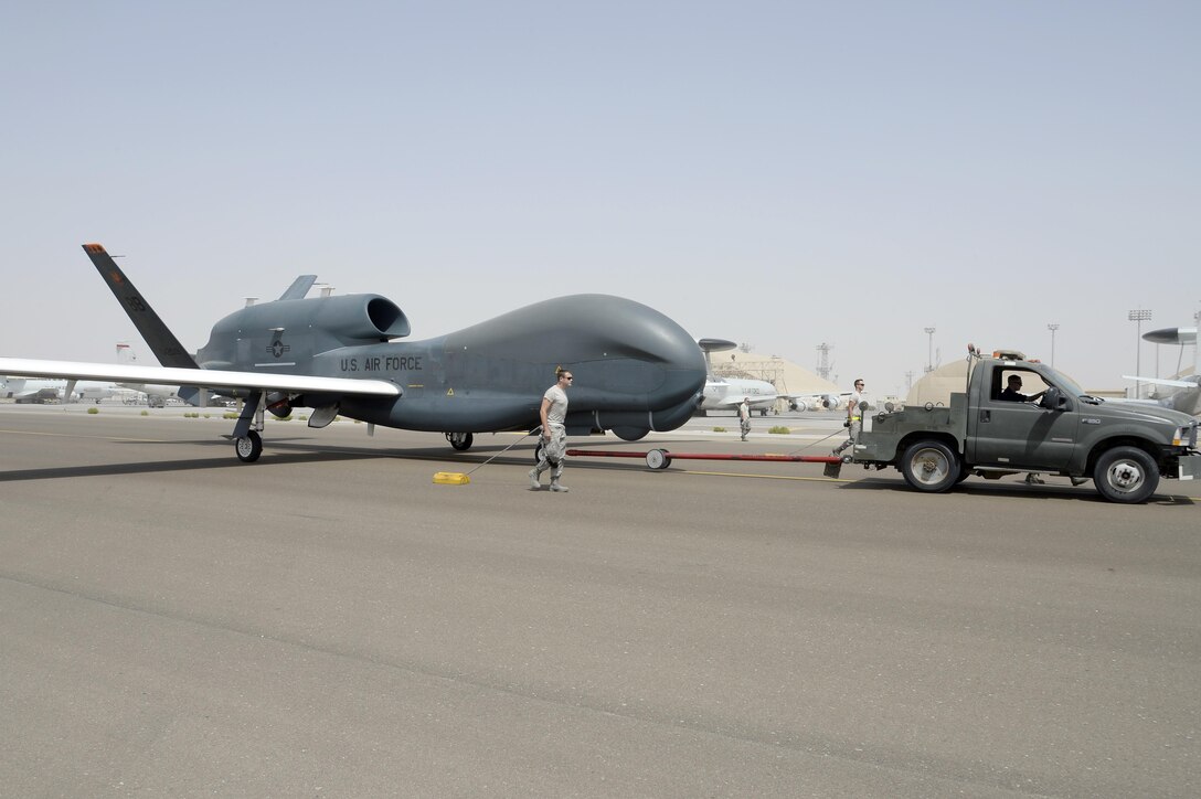 Airmen with the Hawk Aircraft Maintenance Unit walk in a RQ-4 Global Hawk after it landed from a 30.5 hour flight at an undisclosed location in Southwest Asia Mar. 8, 2015. This is one of three block 20 aircraft that carries the Battlefield Airborne Communication Node payload. (U.S. Air Force photo/Tech. Sgt. Marie Brown)