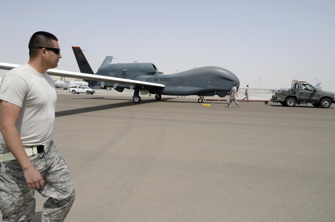 Staff Sgt. Josue, avionics specialist, wing walks in a RQ-4 Global Hawk after a 30.5 hour flight at an undisclosed location in Southwest Asia Mar 8, 2015. Due to the Global Hawk’s large wing span, “wing walkers” are needed to observe the wings and alert the tow supervisor if the wing may hit an obstruction during tow. Josue hails from the state of California and will soon be heading to Beale Air Force Base, Calif. as his next duty station. (U.S. Air Force photo/Tech. Sgt. Marie Brown)